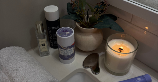 natural deodorant with lavender for sensitive skin without baking soda next to a candle and a plant and other skincare products