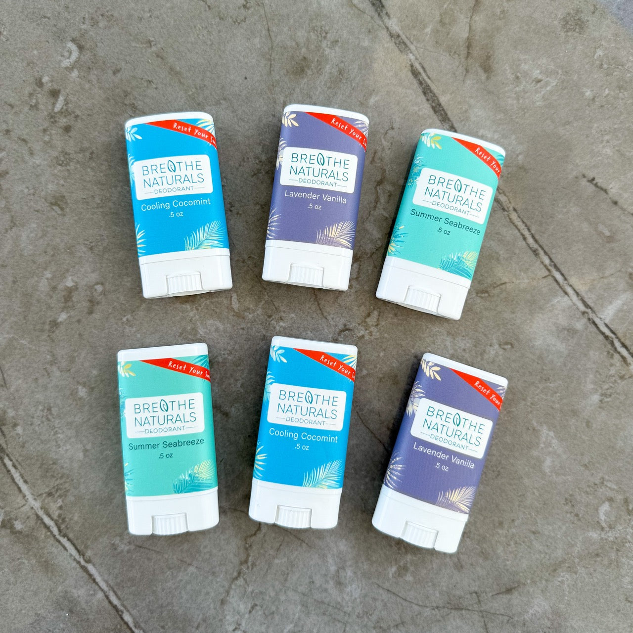 Six Breathe Naturals products on a stone surface