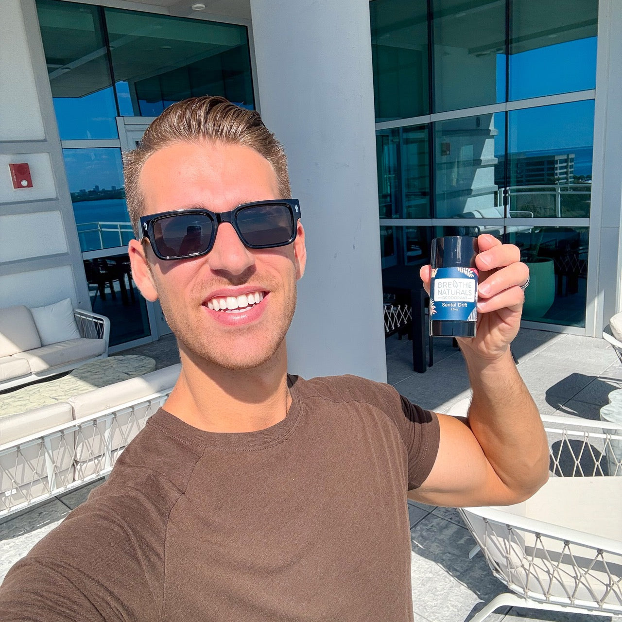 Breathe Naturals effective natural deodorant that works without baking soda or harsh ingredients man holding up deodorant in Tampa Florida